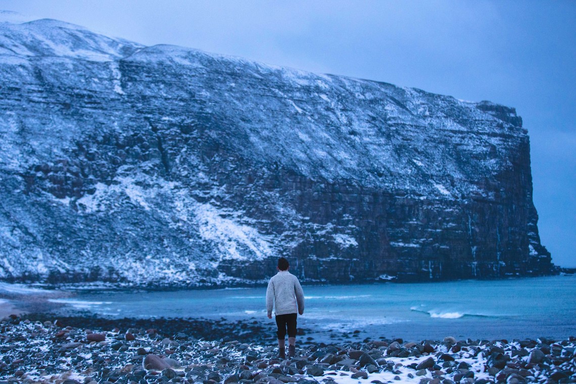 Image of a child staring at a landscape from the shore.